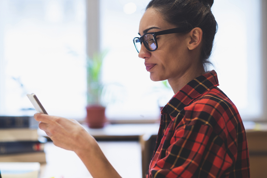 Woman with glasses looking at her mobile phone