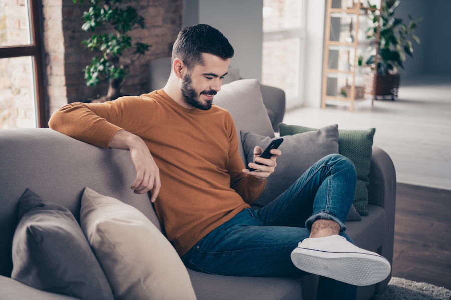 Man texting on couch