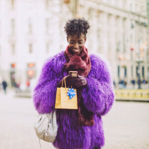 Woman texting and walking with shopping bags