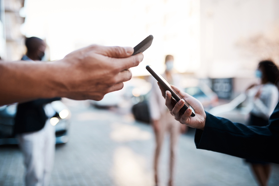 Two people holding their mobile phones.