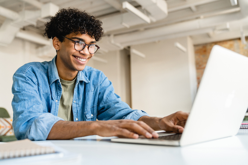Young businessman at computer using Microsoft Teams productivity apps