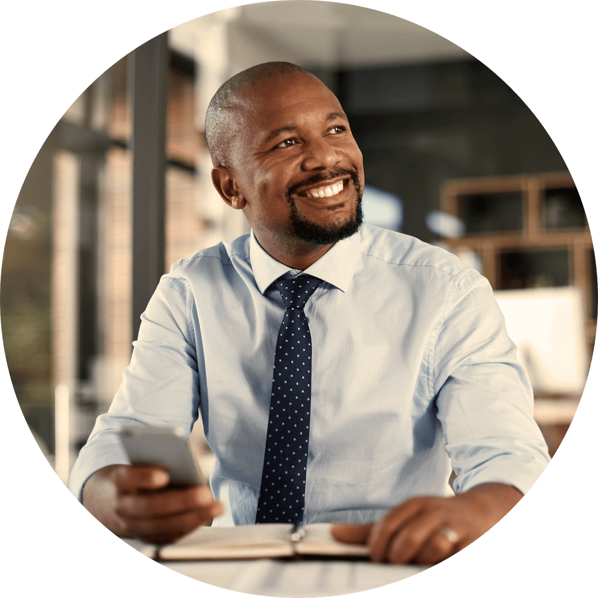 Man at desk with mobile phone using SMS insurance resources