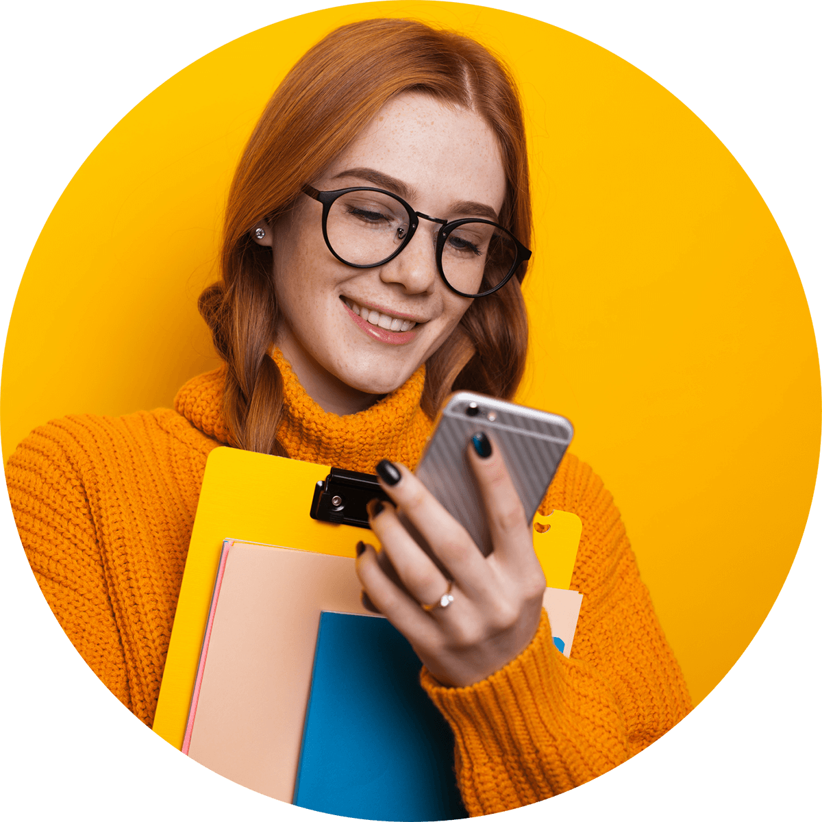 Redhead student with black glasses smiling at phone