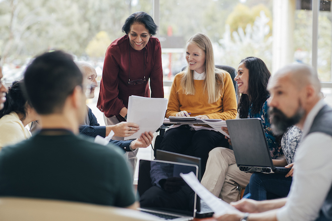 Group of professionals gathered around their computers.