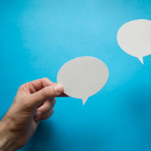 Hands holding paper chat bubbles