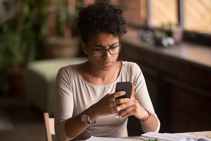 Woman looking concerned at her mobile phone.