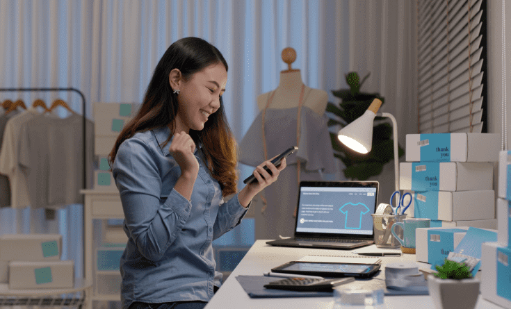 eCommerce store owner smiling and looking at her phone