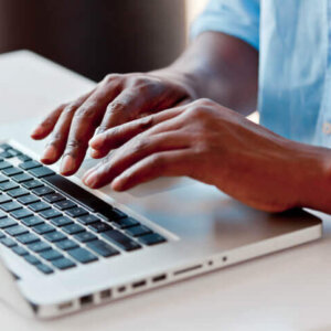 Hands typing on computer